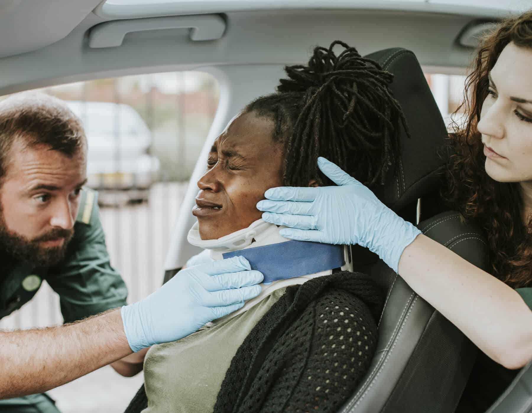 Medical staff putting neck stabilizer on a person in a car accident